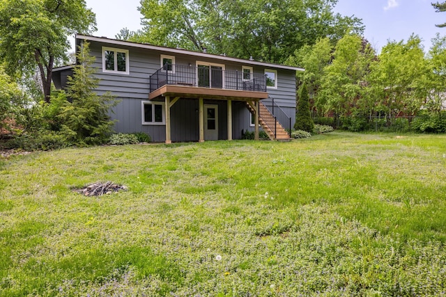 rear view of house featuring a wooden deck and a yard