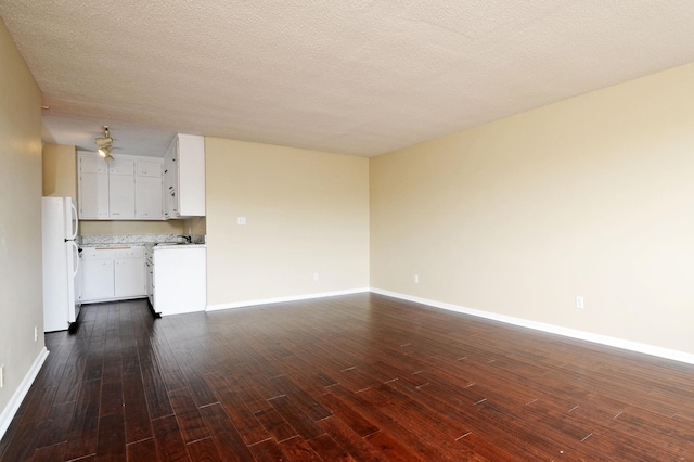 unfurnished living room with dark hardwood / wood-style flooring and a textured ceiling