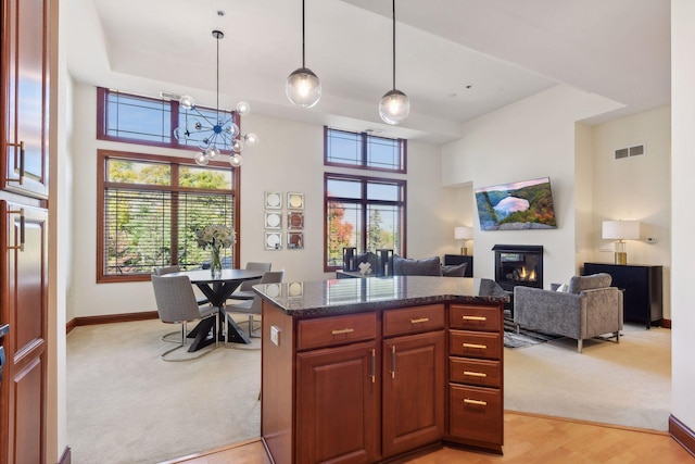 kitchen with hanging light fixtures, a wealth of natural light, light colored carpet, and a chandelier