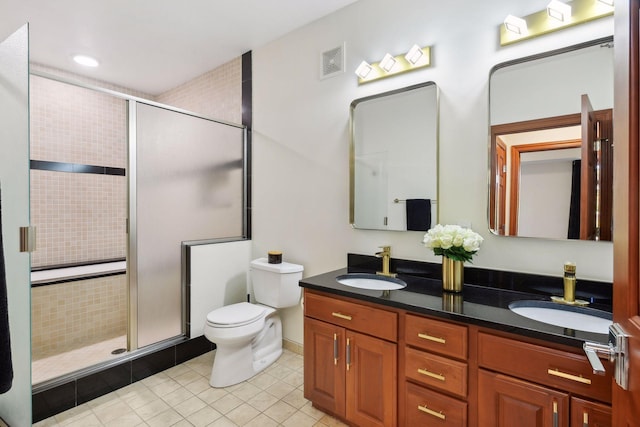 bathroom featuring an enclosed shower, vanity, tile patterned flooring, and toilet