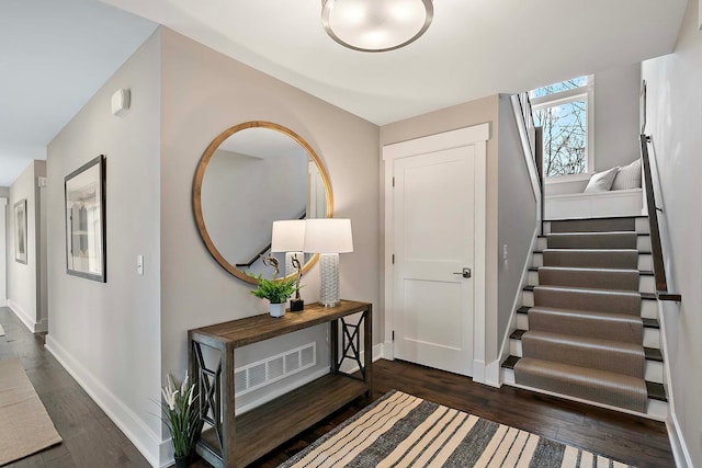 foyer with dark wood-style floors, stairway, and baseboards