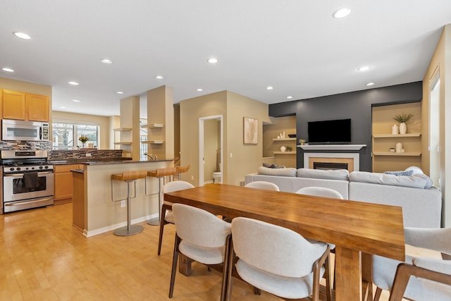 dining room featuring built in shelves and light wood-type flooring