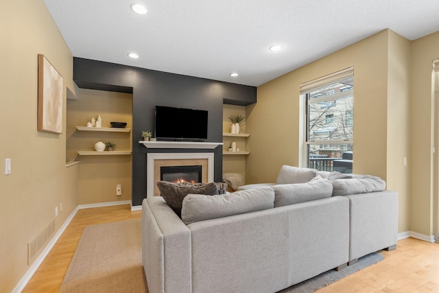 living room with light hardwood / wood-style floors and a textured ceiling