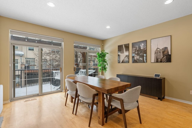 dining room with a textured ceiling and light wood-type flooring