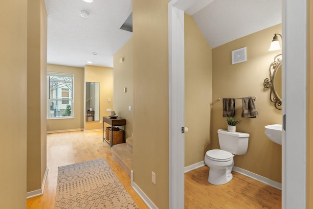 bathroom featuring wood-type flooring and toilet