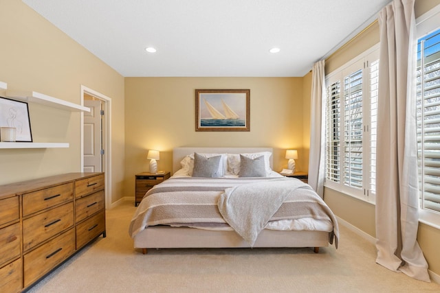 bedroom with multiple windows and light carpet