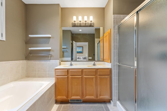 bathroom featuring tile patterned flooring, shower with separate bathtub, and vanity