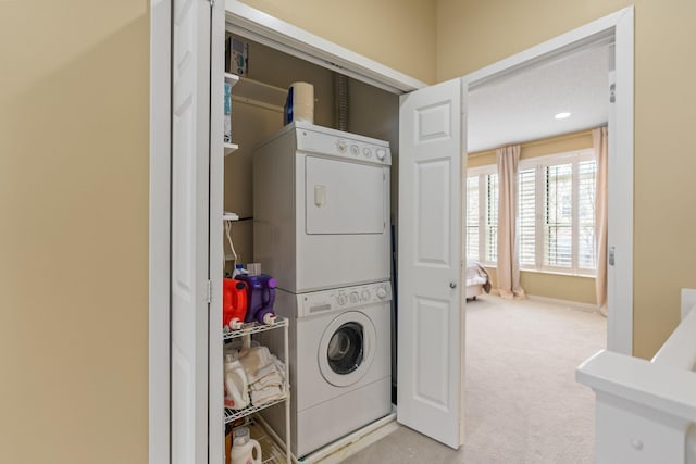 laundry room featuring stacked washer and clothes dryer and light carpet