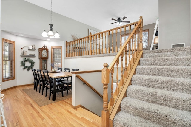 interior space featuring ceiling fan with notable chandelier and hardwood / wood-style floors