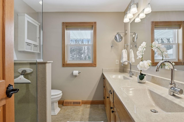 bathroom with vanity, a shower with shower door, and toilet