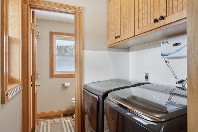 clothes washing area with cabinets and washer and dryer