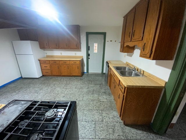 428 10th Ave N, Saint Cloud, MN 56303 - kitchen with a sink, freestanding refrigerator, light countertops, black gas cooktop, and baseboards