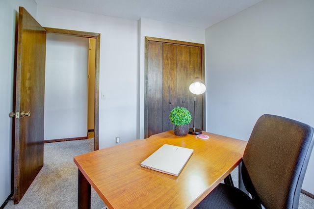 carpeted office space featuring baseboards