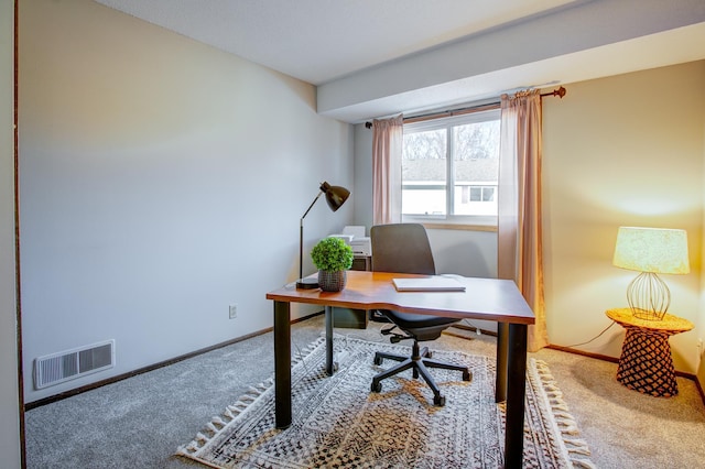 carpeted office featuring visible vents and baseboards