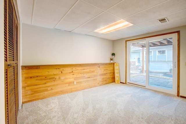 carpeted spare room with visible vents and a paneled ceiling