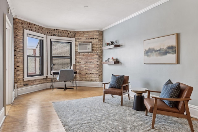 living area with brick wall, ornamental molding, an AC wall unit, and light hardwood / wood-style floors