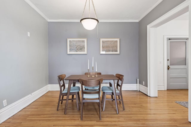 dining area with ornamental molding and light wood-type flooring