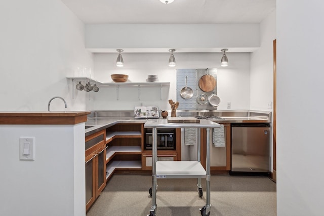 kitchen with stainless steel counters, pendant lighting, and refrigerator