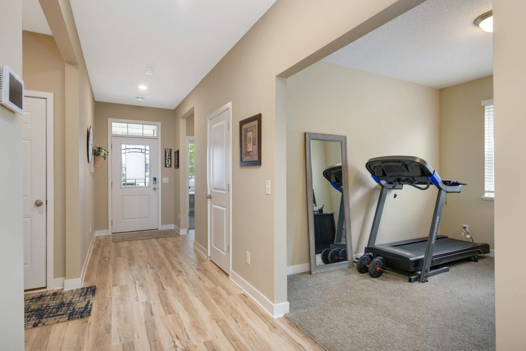 exercise room featuring light wood-type flooring