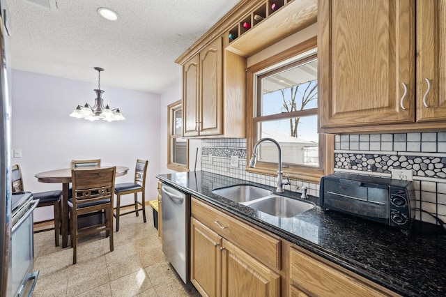 kitchen with baseboards, granite finish floor, a sink, decorative backsplash, and stainless steel appliances