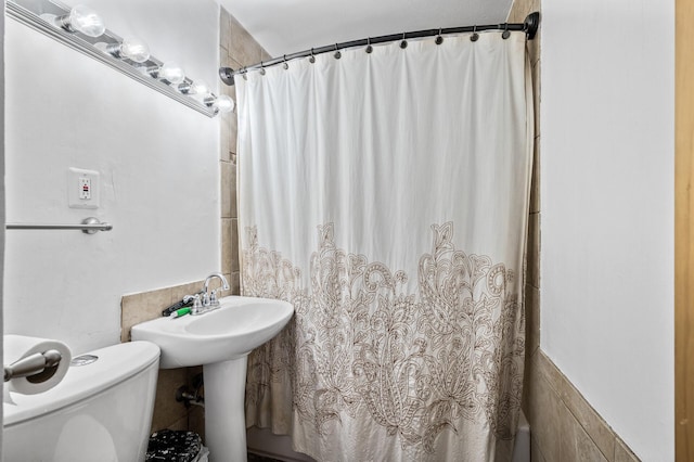 bathroom featuring toilet and a shower with curtain