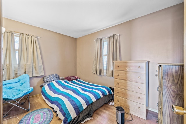 bedroom with baseboards and wood finished floors