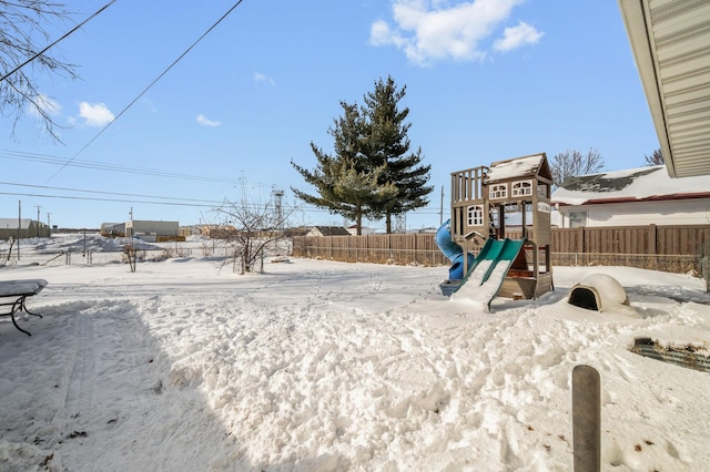 snowy yard with a playground and fence