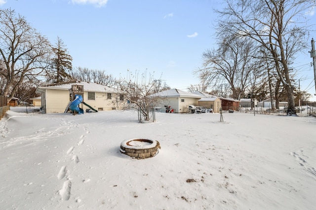 snowy yard with a fire pit and fence