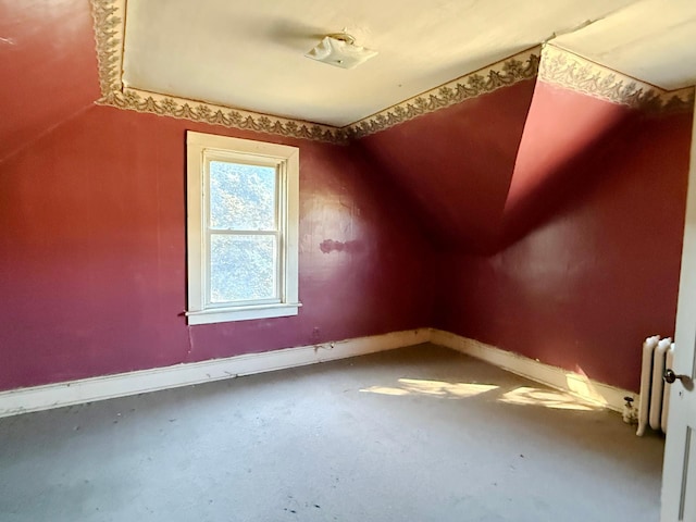 additional living space featuring lofted ceiling and radiator