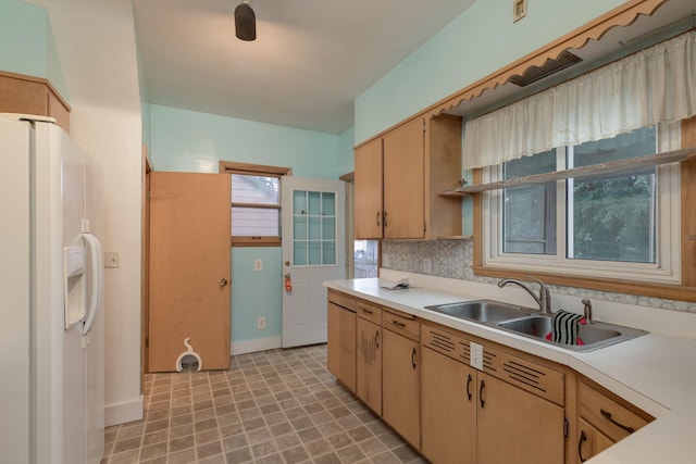 kitchen with white fridge with ice dispenser, sink, light brown cabinets, and decorative backsplash