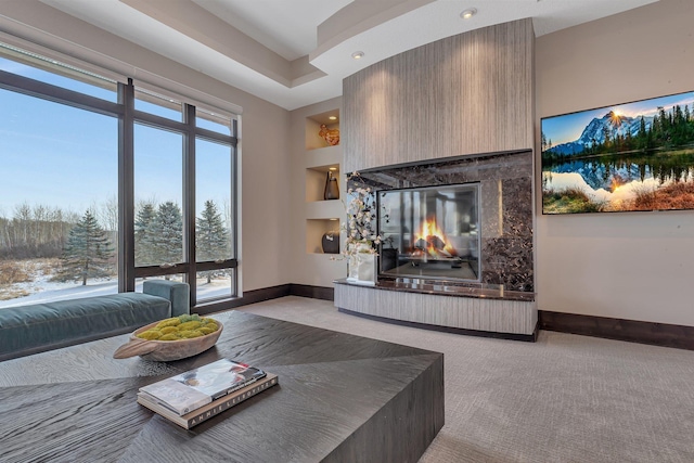 carpeted living room featuring built in shelves, a fireplace, and a wealth of natural light