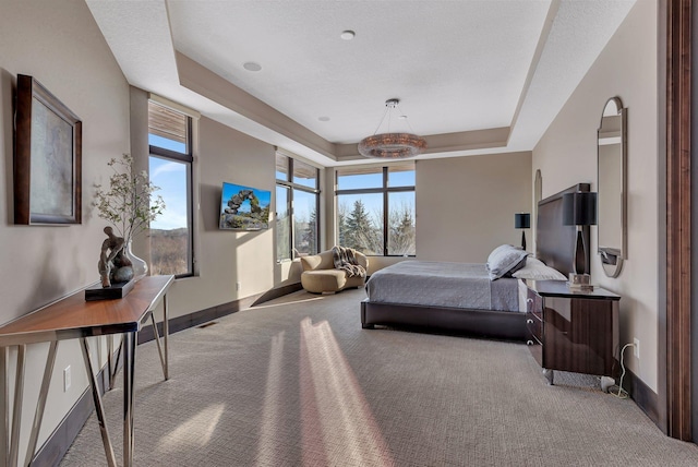 bedroom featuring light colored carpet and a tray ceiling