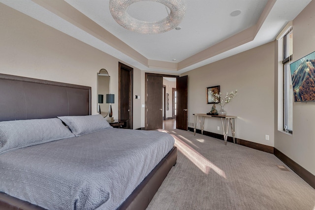 bedroom featuring a tray ceiling and carpet flooring