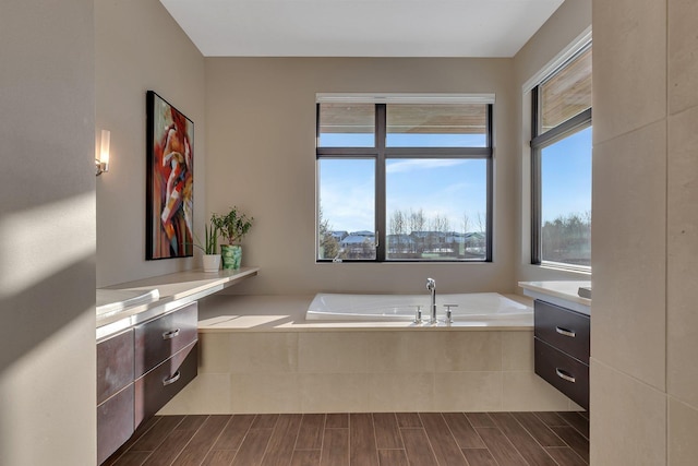 bathroom featuring vanity and a relaxing tiled tub