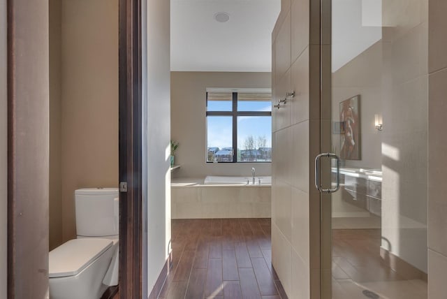 bathroom featuring independent shower and bath, wood-type flooring, and toilet