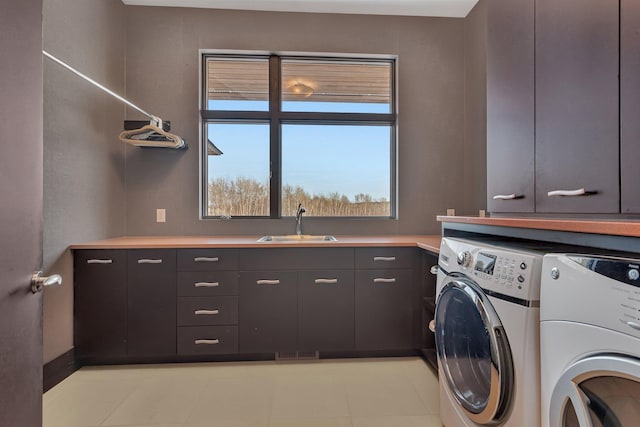 laundry room featuring cabinets, washer and dryer, and sink