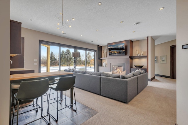 carpeted living room featuring a chandelier and a textured ceiling