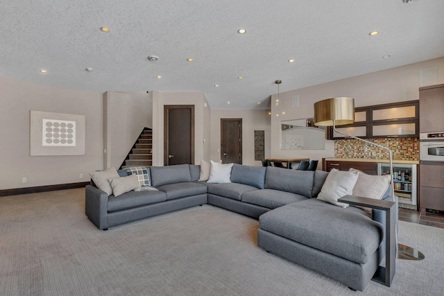 carpeted living room with wine cooler and a textured ceiling