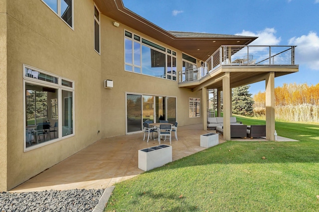 back of property with a lawn, outdoor lounge area, a patio, and a balcony