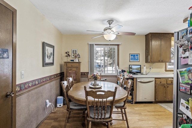 dining area featuring ceiling fan, a textured ceiling, and light hardwood / wood-style flooring