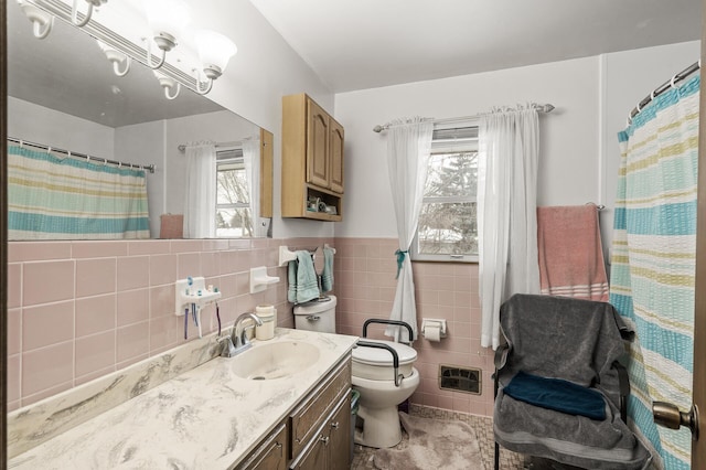 bathroom featuring vanity, toilet, curtained shower, and tile walls