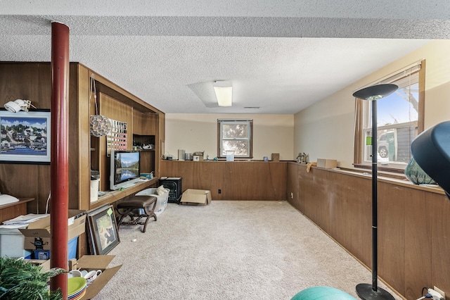 office with light carpet, wooden walls, and a textured ceiling