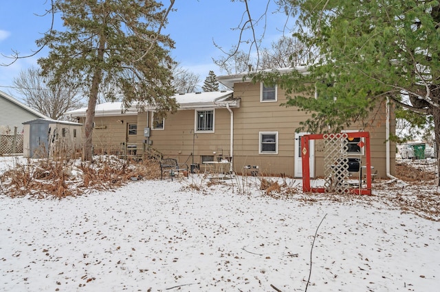 view of snow covered back of property