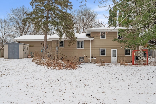 snow covered property with a storage shed