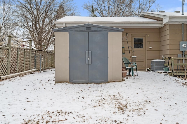 snow covered structure featuring central AC unit