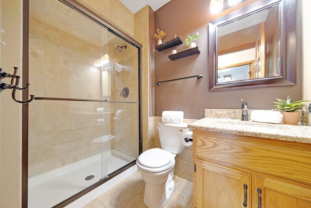 bathroom with tile patterned flooring, an enclosed shower, vanity, and toilet