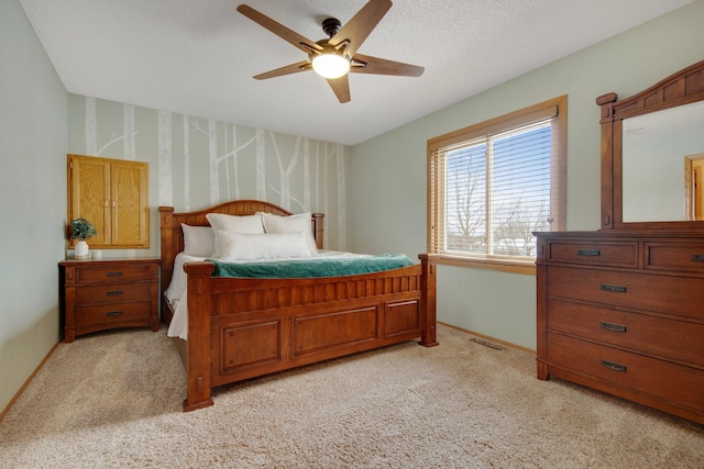 carpeted bedroom featuring ceiling fan and a textured ceiling