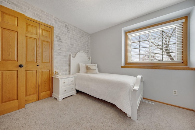 carpeted bedroom featuring a textured ceiling