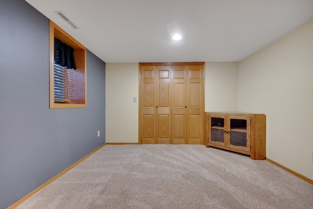 unfurnished bedroom featuring light colored carpet and a closet