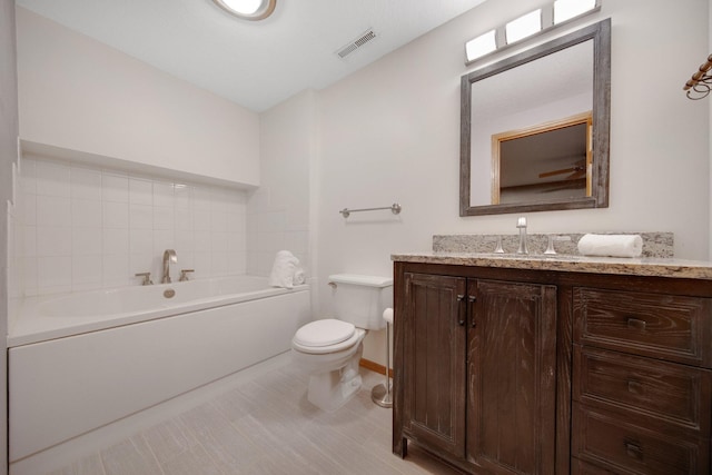 bathroom with vanity, a bathing tub, and toilet